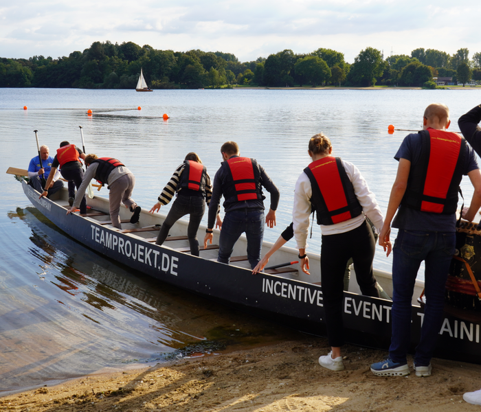 PD-Mitarbeitende steigen im Rahmen eines Firmenevents in ein Drachenboot.