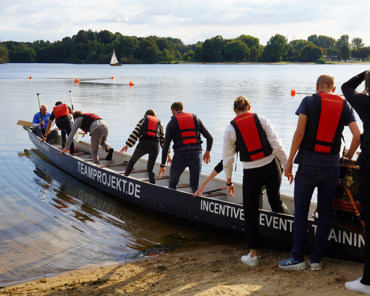 PD-Mitarbeitende steigen im Rahmen eines Firmenevents in ein Drachenboot.