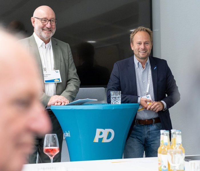 Dr. Johannes Slawig (Senior Expert, PD – Berater der öffentlichen Hand GmbH) und Martin Murrack (Stadtdirektor/Stadtkämmerer, Stadt Duisburg) stehen am Rednerpult