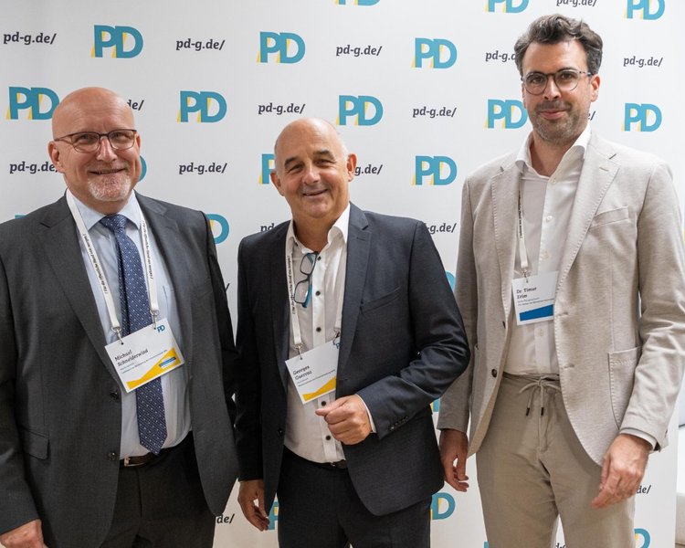 Michael Schneiderwind (Abteilungsleitung, Landesamt zur Bekämpfung der Finanzkriminalität NRW), Georges Guerraz (Fachreferent, Rechenzentrum der Finanzverwaltung NRW) und Dr. Timur Erim (Senior Managing Expert, PD – Berater der öffentlichen Hand GmbH) vor einer PD-Logo-Wand