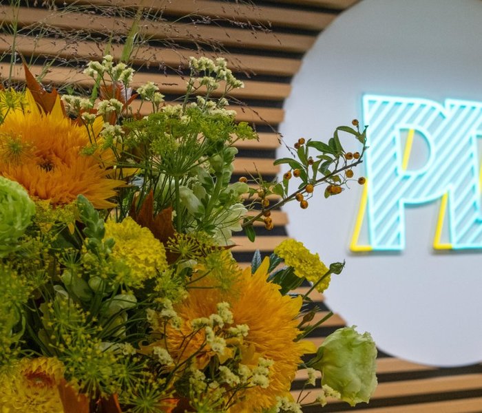 Eingangsbereich des PD-Büros mit PD-Logo und einem Blumenstrauß