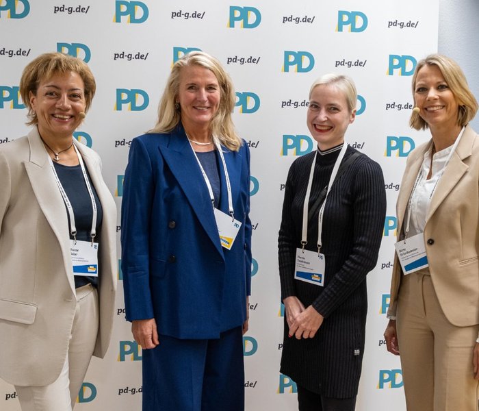 Yvonne Balzer (PD-Standortleitung), Birgit Neyer (Erste Landesrätin und Kämmerin im Landschaftsverband Westfalen-Lippe), Theresa Twachtmann (Geschäftsführerin der PD) und Birte Frischemeier (PD-Standortleitung) vor einer PD-Logo-Wand
