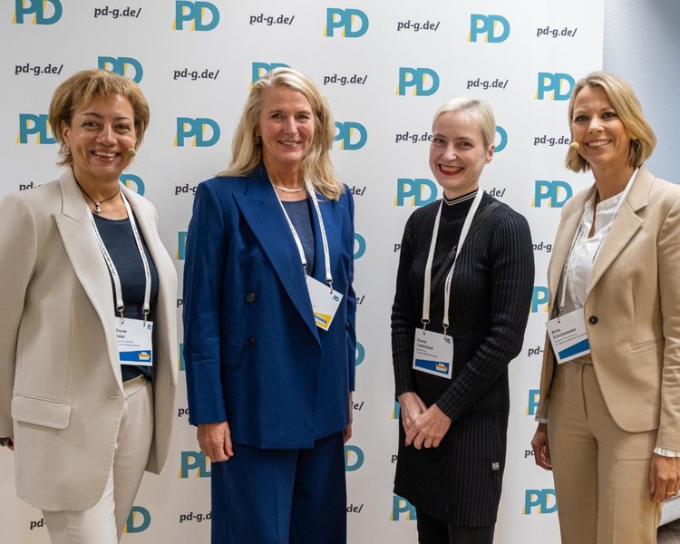 Yvonne Balzer (PD-Standortleitung), Birgit Neyer (Erste Landesrätin und Kämmerin im Landschaftsverband Westfalen-Lippe), Theresa Twachtmann (Geschäftsführerin der PD) und Birte Frischemeier (PD-Standortleitung) vor einer PD-Logo-Wand