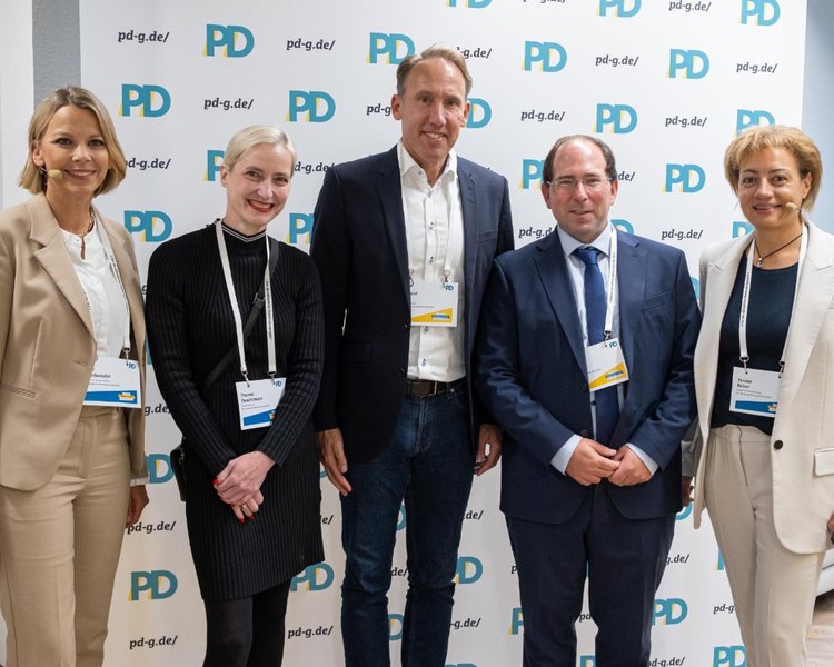 Birte Frischemeier (PD-Standortleitung), Theresa Twachtmann (Geschäftsführerin der PD), Reinhard Derix (Oberfinanzpräsident, Oberfinanzdirektion NRW), Dr. Robin Fink (Referatsleitung, Ministerium der Finanzen des Landes Nordrhein-Westfalen) und Yvonne Balzer (PD-Standortleitung) vor einer PD-Logo-Wand