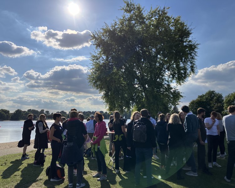 PD-Mitarbeitende sammeln sich nach dem Drachenboot fahren am Ufer.