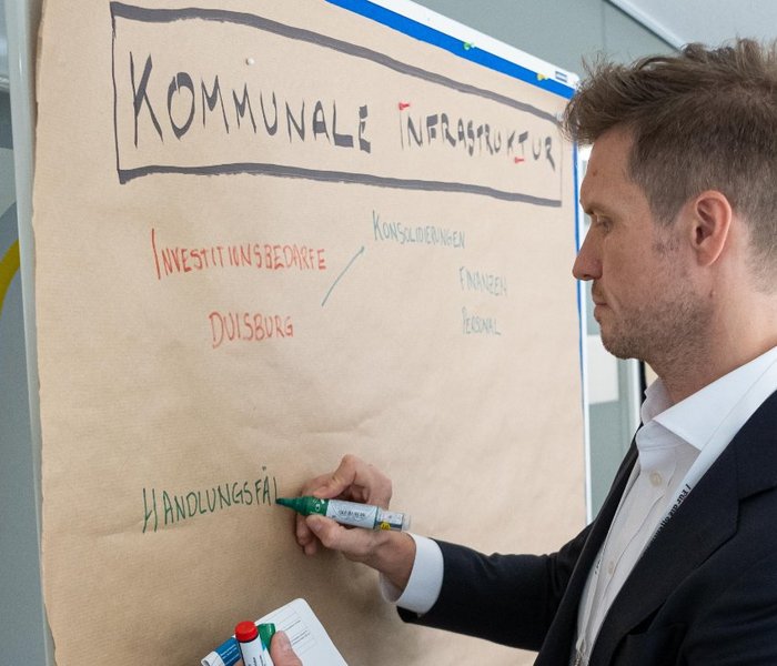 Steven Reinhold (Manager, PD – Berater der öffentlichen Hand GmbH) schreibt auf eine Metaplanwand