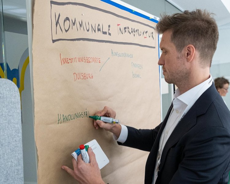 Steven Reinhold (Manager, PD – Berater der öffentlichen Hand GmbH) schreibt auf eine Metaplanwand